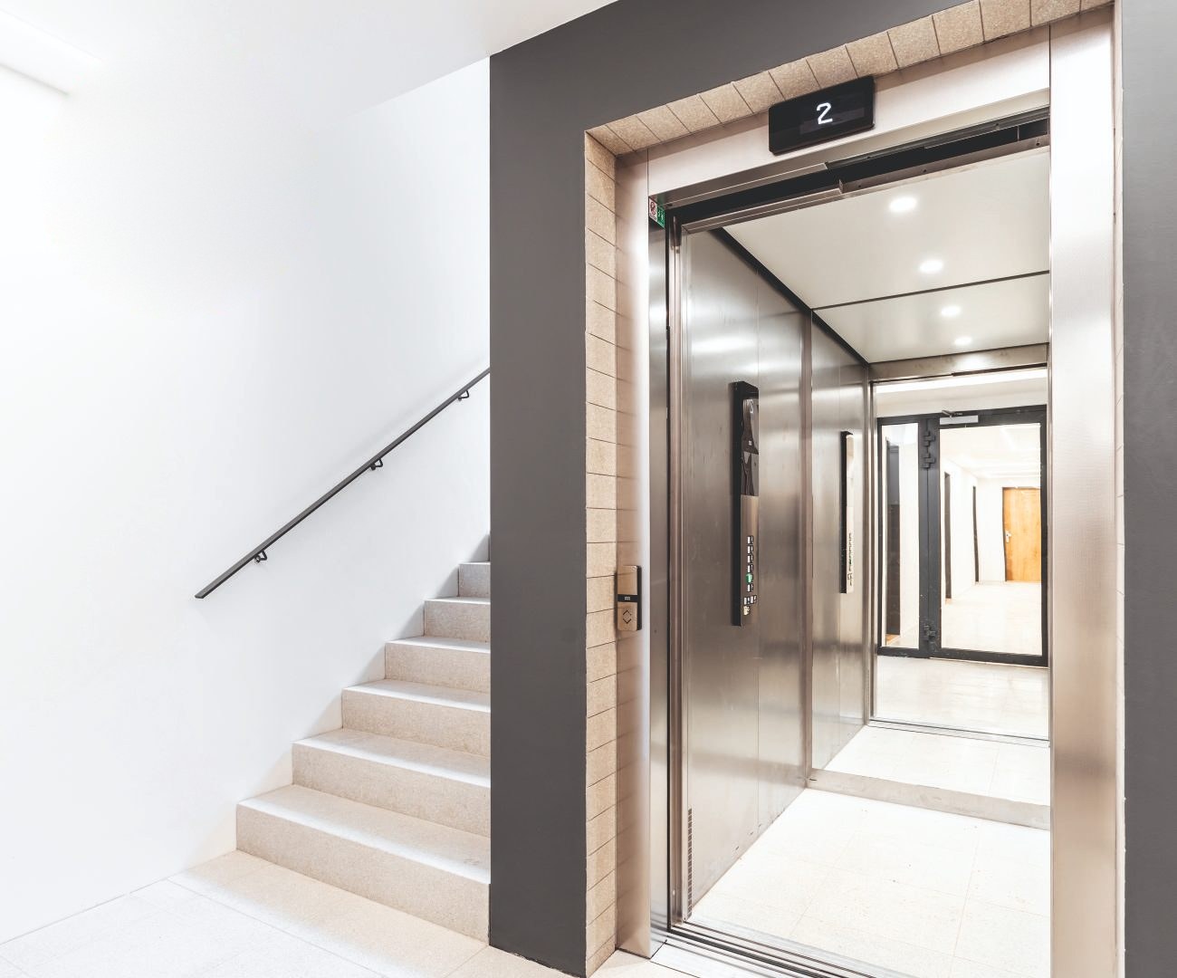 Passenger lift landing beside a staircase